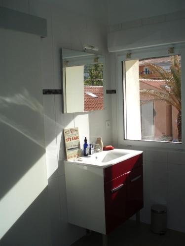 une salle de bain avec un lavabo blanc et une fenêtre dans l'établissement Résidence Robinson Standing Pieds dans l'eau, à Agay