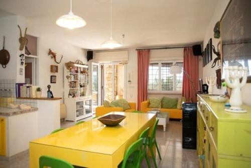 cocina y sala de estar con mesa amarilla en RizzoRelax B&b io mammata e tu en Capilungo