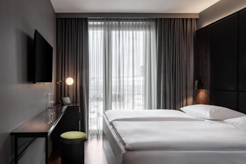 a hotel room with two beds and a window at Hotel ROMY by AMANO in Berlin