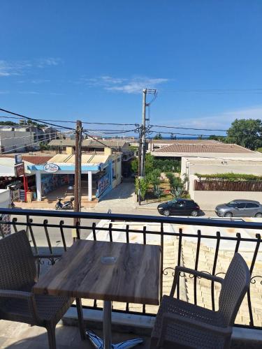 a table and chairs on a balcony with a view of a parking lot at Two Brothers Studios Tsilivi Zakynthos in Tsilivi