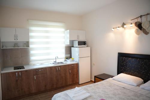 eine Küche mit einem Bett und einem weißen Kühlschrank in der Unterkunft Sofia Residence in Kemer