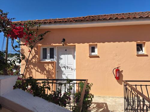 a small house with a white door and stairs at Two Brothers Studios Tsilivi Zakynthos in Tsilivi