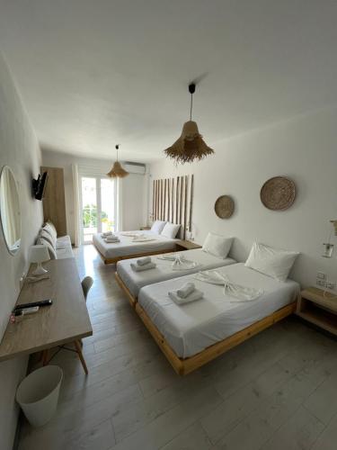 1 dormitorio con 2 camas, escritorio y 1 habitación en Orchard Retreat, en Himare