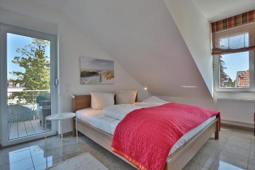 ein Schlafzimmer mit einem Bett mit einer roten Decke in der Unterkunft Villa Seestern Villa Seestern Appartement 8 in Timmendorfer Strand