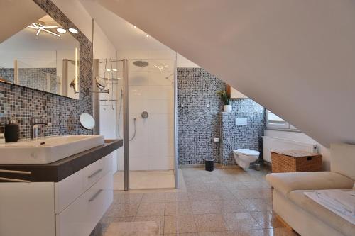 ein Bad mit einem Waschbecken und einer Dusche mit einem WC in der Unterkunft Villa Seestern Villa Seestern Appartement 8 in Timmendorfer Strand