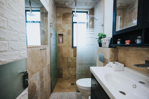 ein Bad mit einer Dusche, einem WC und einem Waschbecken in der Unterkunft בין הפרדס לנחל in Beit Hillel