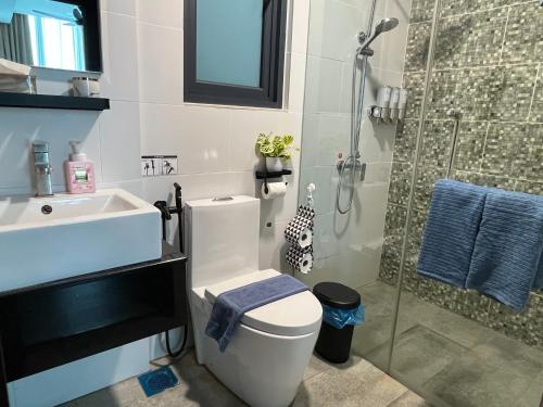 a bathroom with a toilet and a sink and a shower at Home Abroad 1 Jazz Suites Vivacity in Kuching