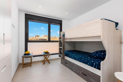 1 Schlafzimmer mit 2 Etagenbetten und einem Fenster in der Unterkunft Spacious Wellness Beach apartment Junogu in San Pedro del Pinatar