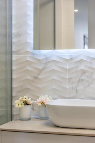 a bathroom with a sink and two vases with flowers at Elegance Apartment Junogu in San Pedro del Pinatar