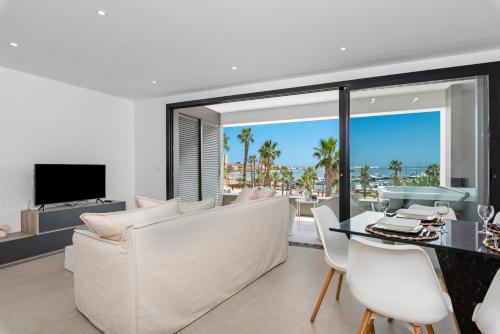 a living room with a white couch and a table and chairs at Elegance Apartment Junogu in San Pedro del Pinatar