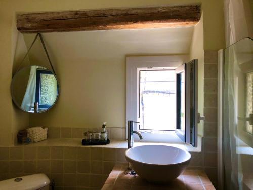 baño con bañera, ventana y lavamanos en Maison des Bourgades, en Saint-Julien-de-Peyrolas
