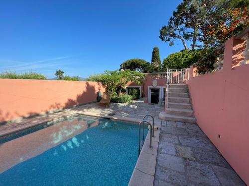 uma piscina em frente a uma casa rosa em Chambre d'hôtes A l'ancre marine em Nice