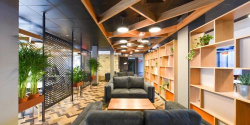 a waiting room with couches and a table and books at Canvas The Heights in Birmingham in Birmingham