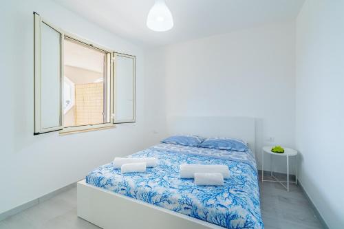 Habitación blanca con cama y ventana en Il Paguro, en Pachino