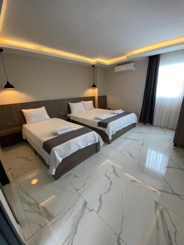 2 camas en una habitación con suelo de mármol en Tuna BUTİK OTEL, en Bodrum City