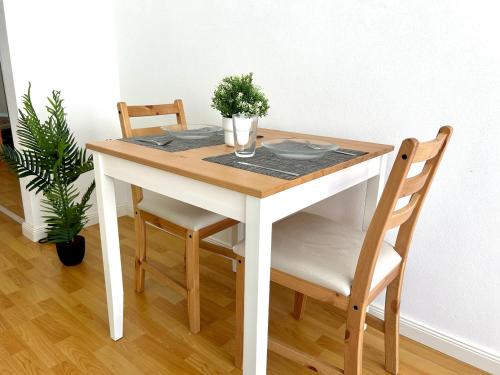 a dining room table with two chairs and a white table at Modern Studio near Lugano's Lake & City Center in Lugano