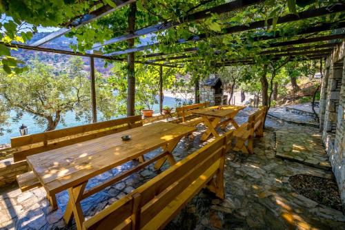 a row of wooden benches sitting under a pergola at Petra Mare Apartments in Alyki