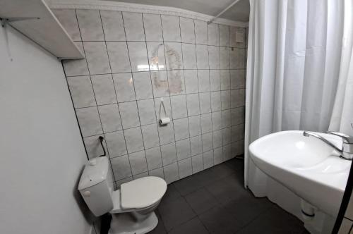 a white bathroom with a toilet and a sink at Śródziemie Rohan in Leśno