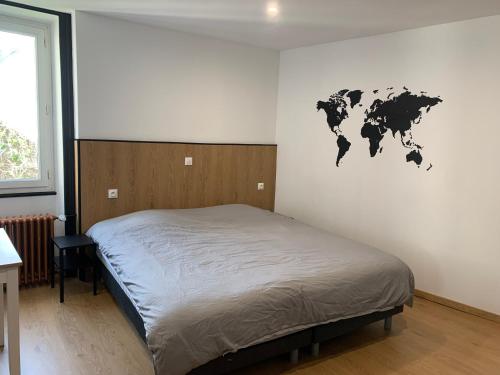 una camera con un letto e una mappa del mondo sul muro di Au coeur de la ville a Bourges