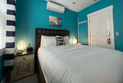 a bedroom with a large bed with blue walls at Lotus Provincetown in Provincetown