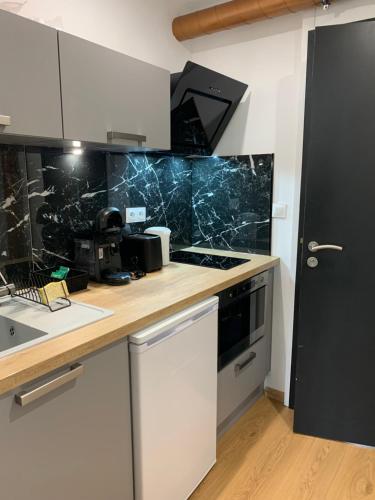 une cuisine avec un comptoir avec une cuisinière et un four dans l'établissement Au coeur de la ville, à Bourges