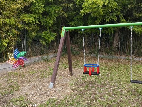 a swing set in a yard with two toys at AGRITURISMO COLOMBARE TEBOI in Lazise