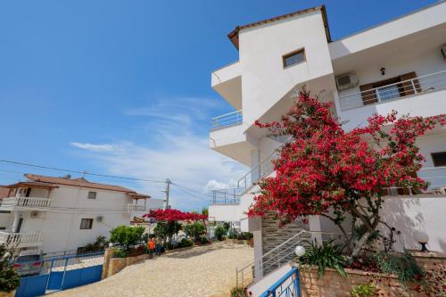 a building with red flowers in front of it at Vila Genci in Ksamil