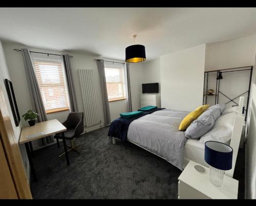 a bedroom with a bed and a desk with a chair at Beach retreat! in Pakefield
