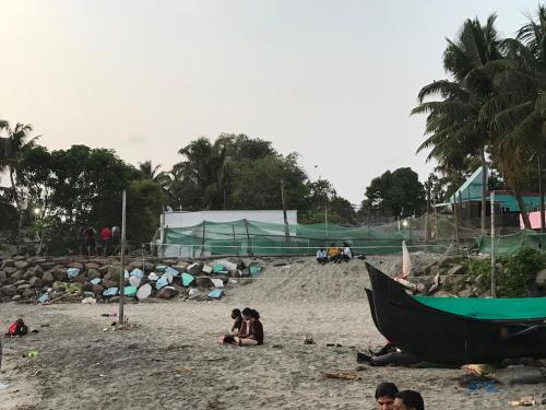 un grupo de personas sentadas en una playa de arena en Gods own home stay en Kochi