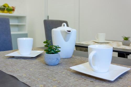 a table with two white cups and a plant on it at Irini Luxury Rooms in Split