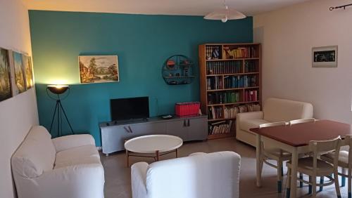 un soggiorno con mobili bianchi e una parete blu di La Sbecciatrice a Villa Santa Croce