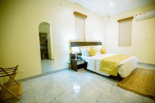 a bedroom with a large bed and a mirror at Apartment 79 Hotel & Suite in Ikeja