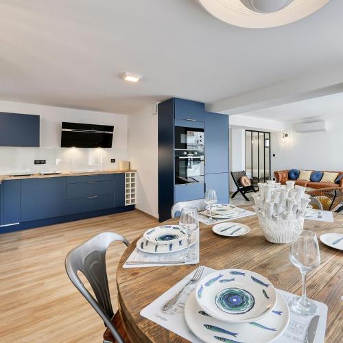 une salle à manger avec une table et des chaises ainsi qu'une cuisine dans l'établissement Grande Plage, à Saint-Georges-de-Didonne