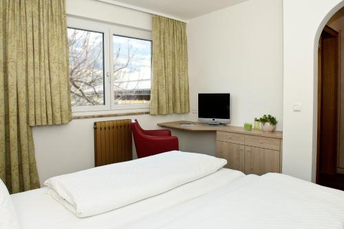a bedroom with two beds and a desk with a computer at Gasthaus Bacher in Sankt Johann im Pongau
