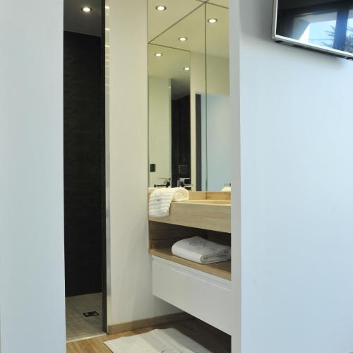 ein Bad mit einem Waschbecken und einem Spiegel in der Unterkunft Grande Plage in Saint-Georges-de-Didonne