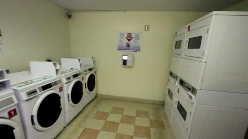 a laundry room with white washers and dryers at InTown Suites Extended Stay Gulfport in Gulfport