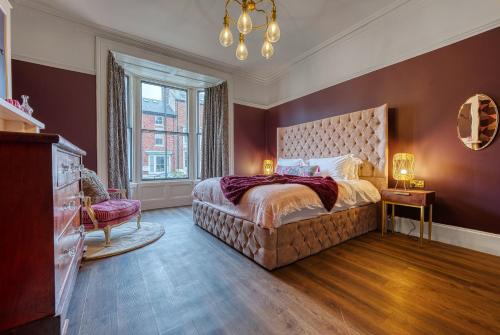 a bedroom with a large bed and a large window at Casa Del Artista , Boutique Apartments, Whitby in Whitby