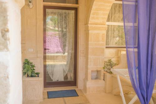 eine Eingangstür eines Hauses mit Fenster in der Unterkunft B&B Tenuta Martinelli in Monopoli