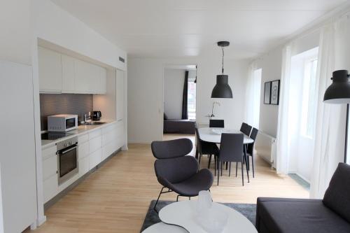 哥本哈根的住宿－Three Bedroom Apartment In Copenhagen S, Cf Mllers Alle 56，厨房以及带桌椅的起居室。