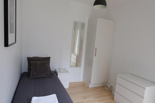 a white bedroom with a bed and a mirror at Three Bedroom Apartment In Copenhagen S, Cf Mllers Alle 56 in Copenhagen