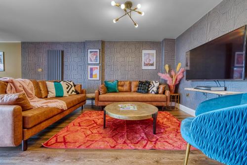 a living room with two couches and a table at Casa Del Artista , Boutique Apartments, Whitby in Whitby