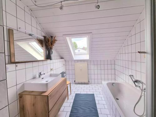 a bathroom with a sink and a tub and a mirror at Ferienwohnung Waldengel in Bad Abbach