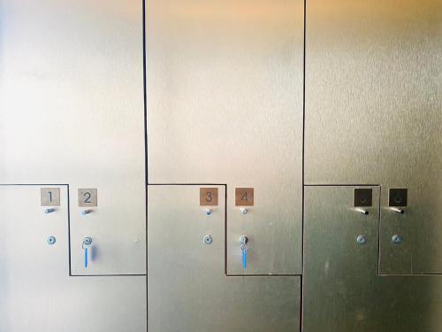 a bathroom with a door with buttons and a mirror at Edge Central Pattaya Vip Condo in Pattaya Central