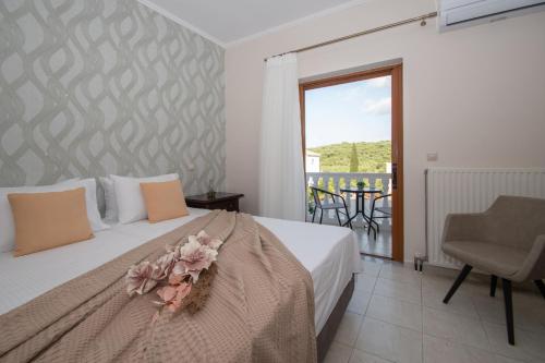 a bedroom with a bed with a flower arrangement on it at Kozanos Hotel & Suites in Amoudi