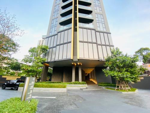 a tall building with a car parked in a parking lot at Edge Central Pattaya Vip Condo in Pattaya Central
