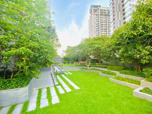 a garden with benches and grass and buildings at Edge Central Pattaya Vip Condo in Pattaya Central