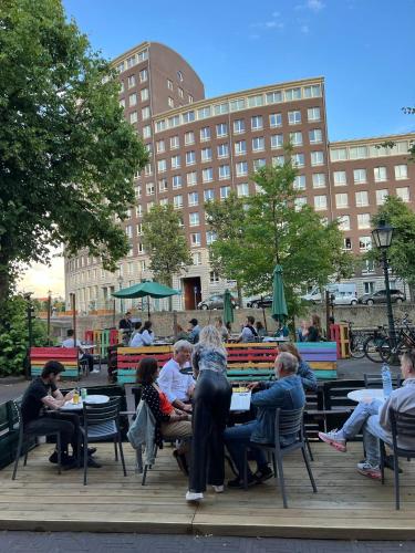 a group of people sitting at tables in a park at Hostel The Golden Stork in The Hague