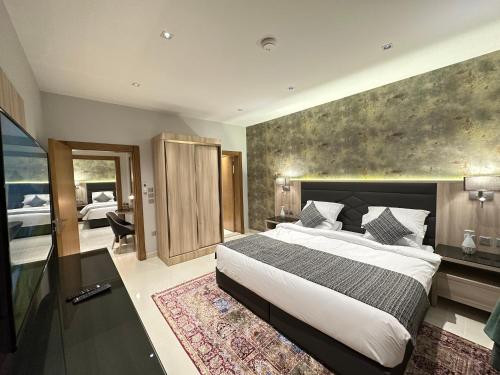 a bedroom with a large bed and a bathroom at Mehad Stay for Self Check-In Apartment in Jeddah