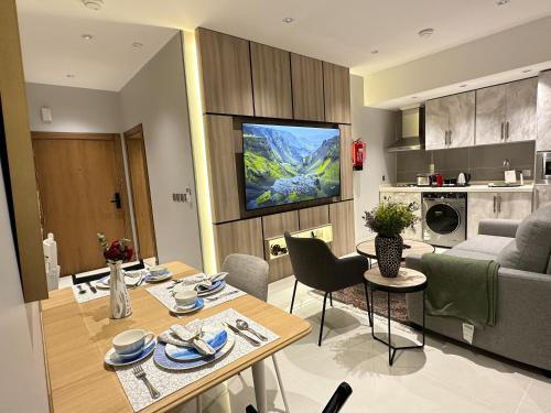 a kitchen and living room with a table and a couch at Jeddah Luxury stay for Self Check-In Apartment in Jeddah