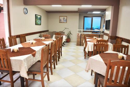 a dining room with tables and chairs in a restaurant at Ивелия Къща за гости in Dospat